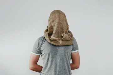 Man with veiled face on a light background. The concept of kidnapping, detention, and crime. No...