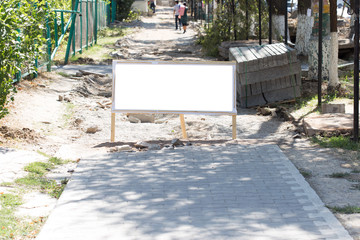 Blank white sign on the sidewalk under construction