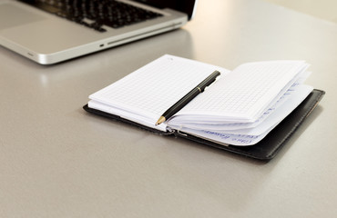 View from above of the modern office wood desk with a laptop, a notebook and pen. Copy space available.