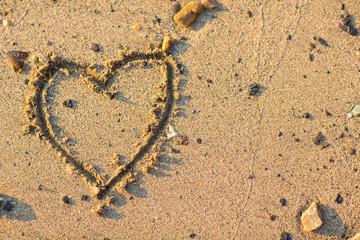 a heart in the sand on the beach.heart drawn on sand. horizontal composition.