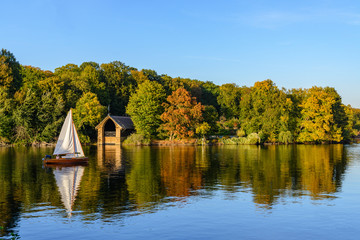 Natural landscape view of forest with autumn leaves in Pfaueninsel island and boat sail at Wannsee lake,  Havel river from colour changed grassland on waterside of Westlicher Düppeler forest, Berlin. © Peeradontax