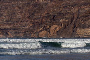 textured rock and ocean waves in the evening sun