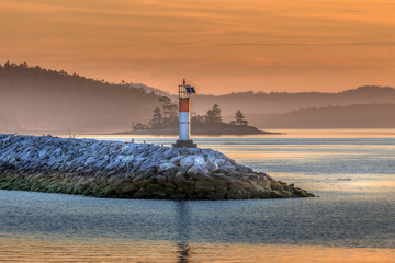 Fototapeta premium Small lighthouse with beautiful sunrise on north west coast