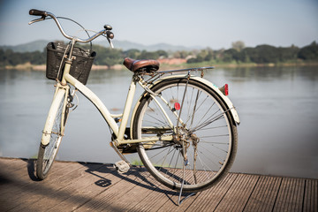 Fototapeta na wymiar Bicycle near lake during sunset.Vintage bike near the lake in the evening, warm sunset view.