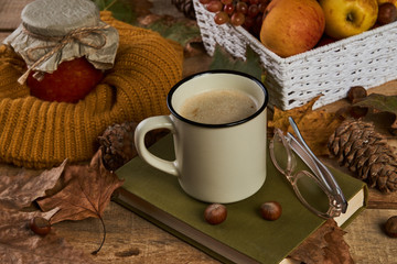 Autumn season and education concept with book reading glasses, fruits basket, fir cone and nuts on old rustic wooden table background with copy space, close-up, top view