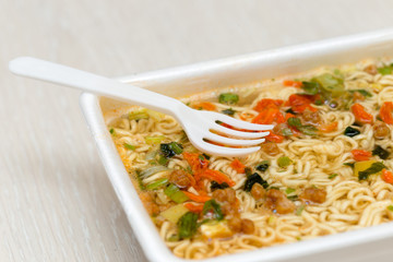 Raw food noodles quickly with a fork on the table