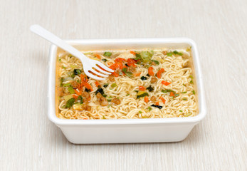 Raw food noodles quickly with a fork on the table