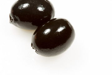 Ripe black olives on a white background