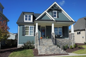 Exterior view of a two-story suburban home with a stone porch in autumn.  Built in 2017 in North...