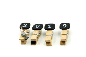 Miniature people : sitting with Clothespins of word 2019 Education and business design concept  using for  coming New Year 2019.