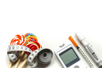 Sweet candy with Insulin syringe,lancet,test strip,glucose meter and lancing device concept of diabetes and reduction of eating sweets