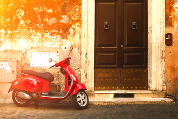 Naklejka premium Red scooter on an old narrow street in Rome