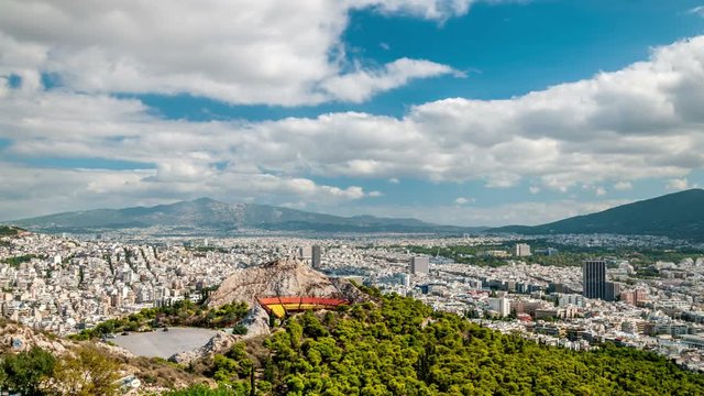Panoramic view of Athens, Greece. City skyline. White clouds move fast across the blue sky. Time lapse video.