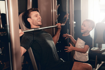 Son Support To Father While Lifting The Barbell.