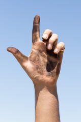 Dirty hands against the blue sky