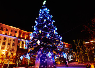 Christmas tree on square, evening street, blue lights 