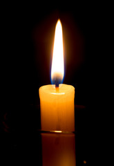 candle lit brightly against a black background
