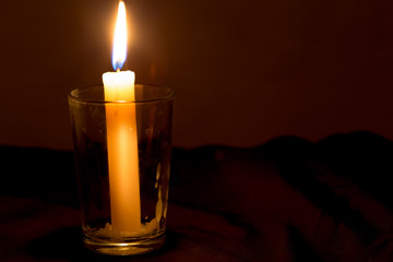 candle lit brightly against a black background
