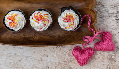 3 cupcakes with pink hearts