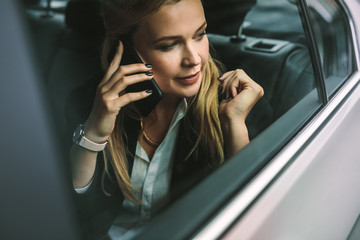 Businesswoman talking on the cellphone in car
