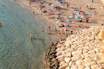 Cala mal pas de Benidorm llena de gente irreconocible bañandose en el agua del mar y tomando el sol en la arena de la playa