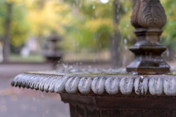Vintage Bronze Fountain on the Blurred Autumn Park Background. Foreground Focus.