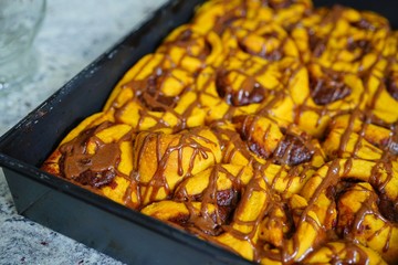 Tray of freshly baked vegan pumpkin cinnamon rolls with cinnamon icing