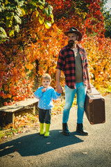 Happy family, father and baby son playing and laughing on autumn walk. Both dad and child are...