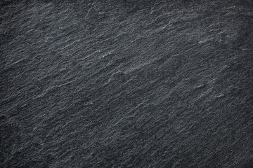 Dark grey / black slate background or texture.
