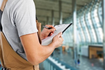 Worker of brewery taking notes at warehouse