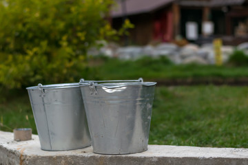 galvanized buckets in the territory of the country yard or the tourist complex under construction for rest and pastime