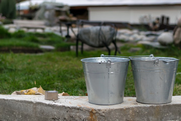 Naklejka premium galvanized buckets in the territory of the country yard or the tourist complex under construction for rest and pastime