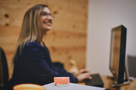 Defocused Image Of Receptionist Working In Dental Office