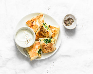 Fried stuffed chickpeas, spinach, leek and mozzarella rolls on a light background, top view....