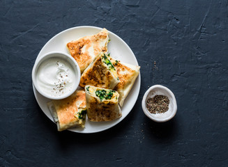 Rolls stuffed with chickpeas, spinach, leek and mozzarella on a dark background, top view. Tasty snack