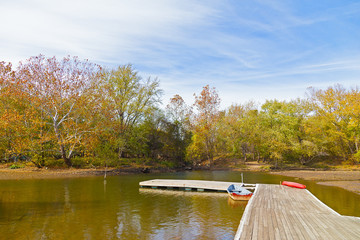 Autumn in a park along C&O Canal and Potomac River in Washington DC, USA. Boats pier for water activities on the river.