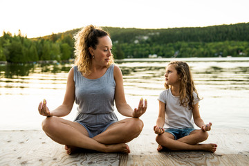 Fototapeta na wymiar Happy family mother and child daughter doing yoga