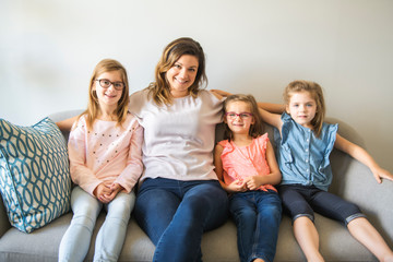 Fototapeta premium mother and daughters on sofa at home