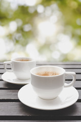 Couple cup of hot coffee on wooden table have bokeh in background, coffee in morning.