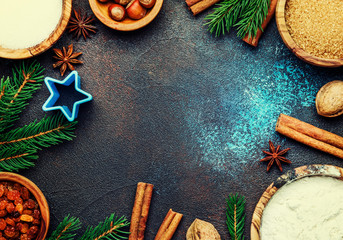 Christmas or New Year composition with ingredients for baking or with golden snowflakes, Christmas balls, green fir branches, pine cones, on blue brown background, frame, top view
