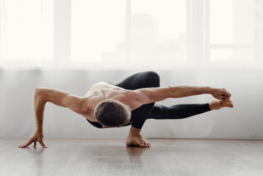 Strong flexible man doing morning yoga exercises