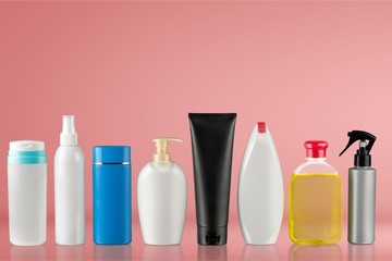 Cosmetic containers isolated on simple blue background, perfume