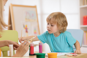 little cute boy painting pictures in art studio