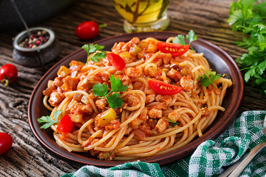 Spaghetti bolognese pasta with tomato sauce, vegetables and minced meat - homemade healthy italian pasta on rustic wooden background.