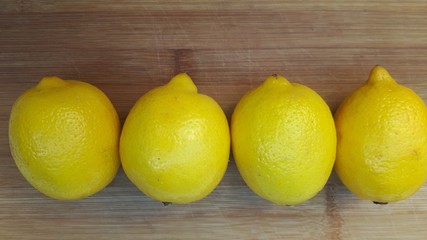 4 citrons jaunes sur fond en bois