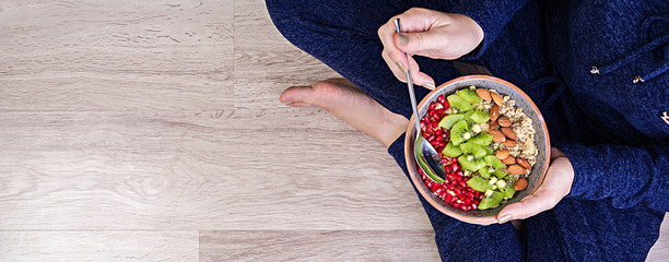 Fitness and healthy lifestyle concept. Female is resting and eating a healthy oatmeal after a...