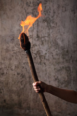 Human hand holding a flaaming torch