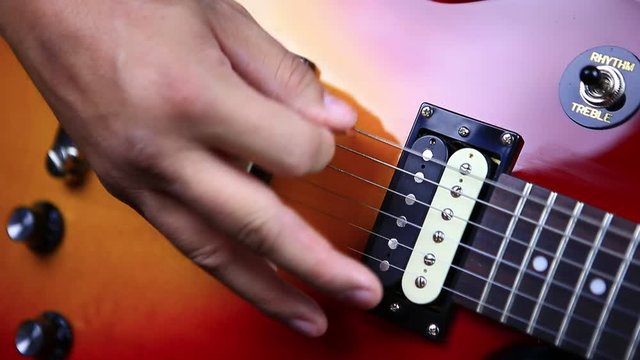 Man picking notes on electric guitar in repeating sequence - rolling arpeggio close up.MOV