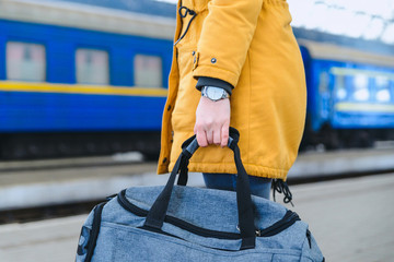 woman hold bag on railway station. watch on wrist.