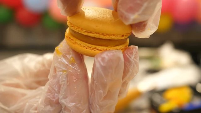 confectioner making french macaron cake in hands 4k.